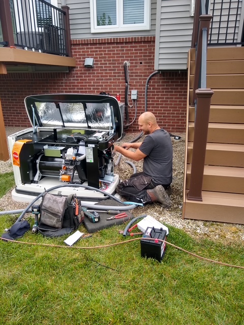 budget electric worker doing maintenance on a generac generator behind a home